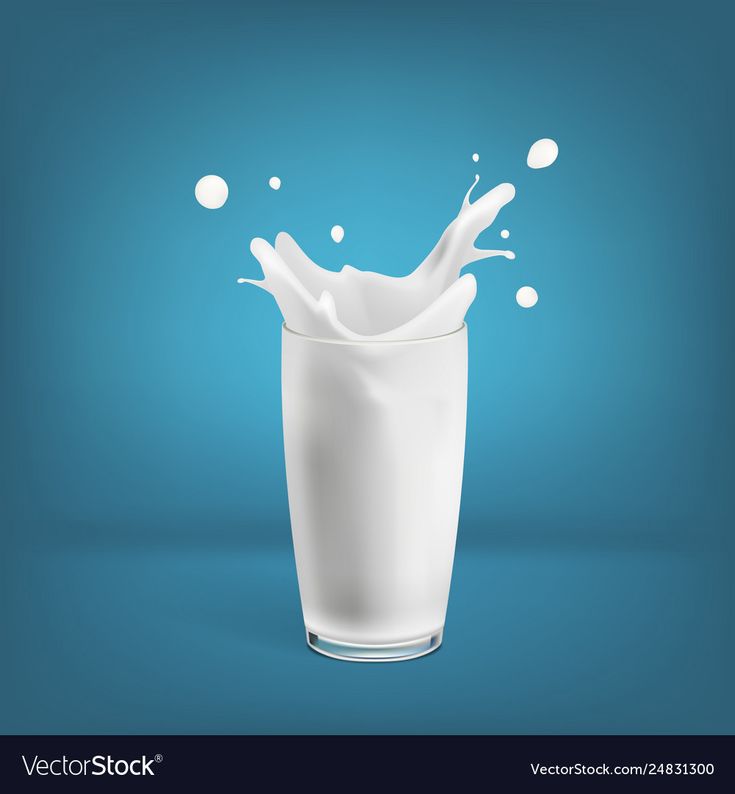 milk splashing into a glass on blue background