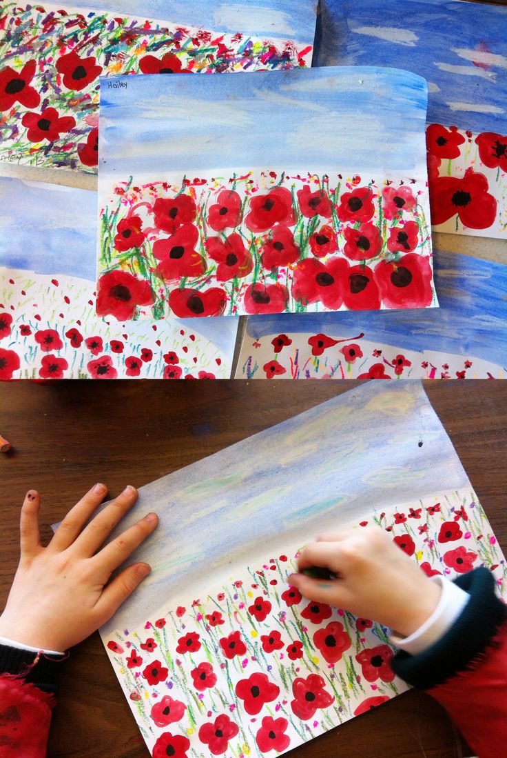 child's hands painting poppies on paper