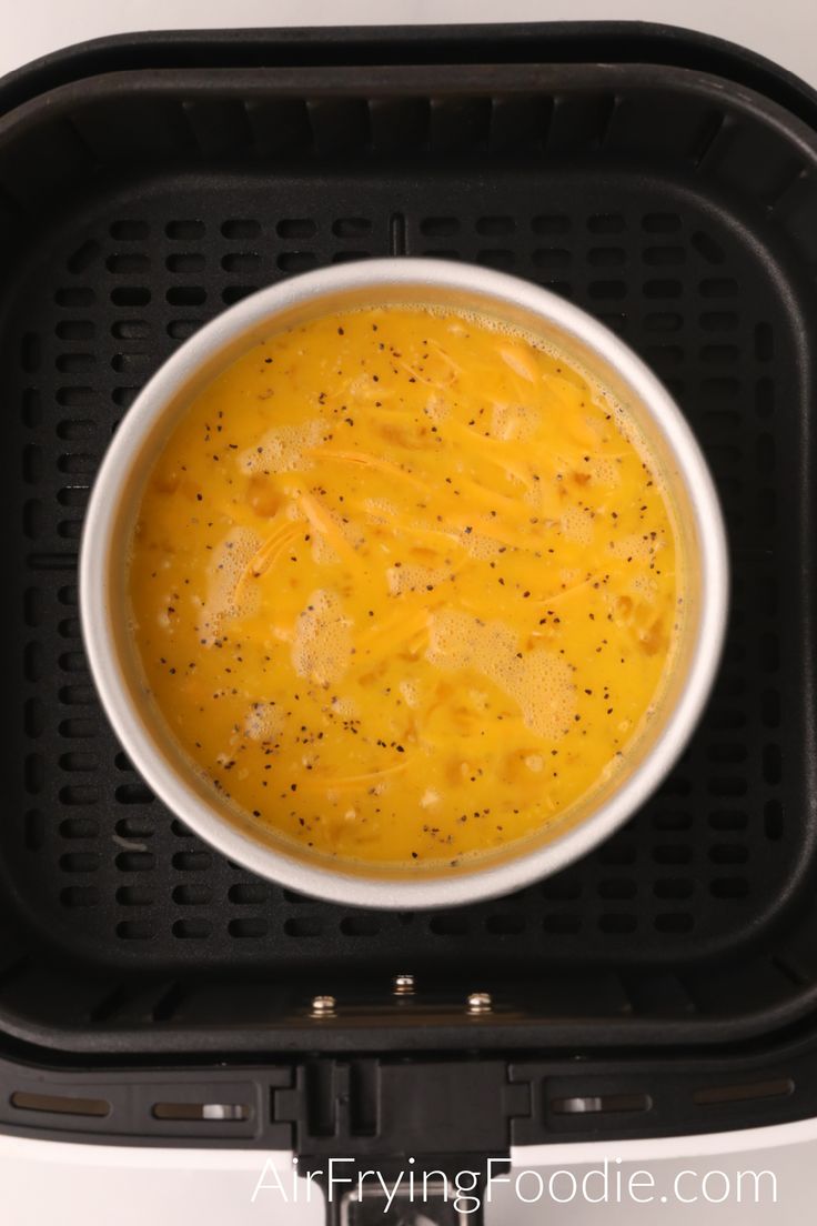 a white bowl filled with soup sitting on top of a black plastic container in an air fryer