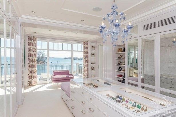 a large white room with a chandelier hanging from the ceiling and lots of drawers