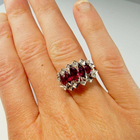 Here we have an exceptional one of a kind natural earth mined no heat ruby and sparkly diamond ring dating to the mid century era. True to the most luxurious vintage jewelry this special ring is completely handmade. There are no cast or machined components. In total there are 3.51 carats of beautifully cut unheated red rubies. The total diamond weight is 0.10 carats. This makes the total ruby and diamond weight 3.61 carats in this ring.Made entirely out of solid 18K white gold the ring weighs ap Diamond-encrusted Ruby Promise Ring, Hallmarked Emerald Cut Ruby Anniversary Ring, Diamond Ruby Promise Ring Hallmarked, Anniversary Hallmarked Ruby Ring With Cubic Zirconia, Promise Ruby Ring With Diamond Hallmarked, Anniversary Hallmarked Cubic Zirconia Ruby Ring, Heirloom Ruby Ring With Three Stones, Heirloom Ruby Three Stone Ring, Marquise Cut Ruby Diamond Ring With Prong Setting