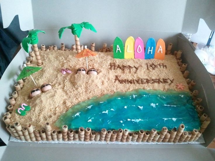 a cake in the shape of a beach with surfboards and palm trees on it