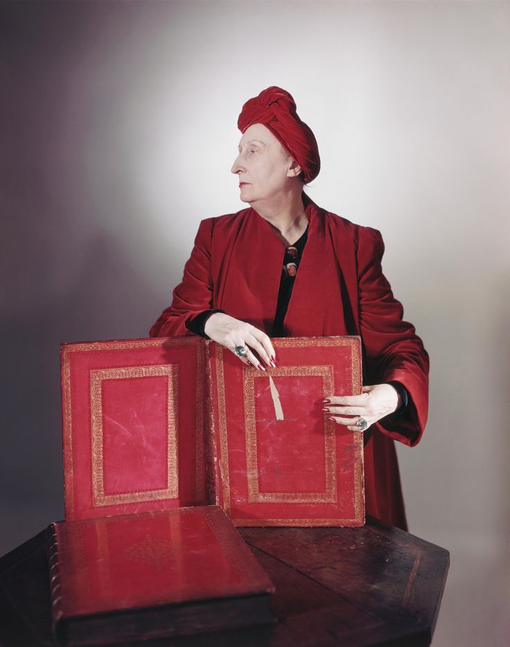 a woman holding two red boxes on top of a table