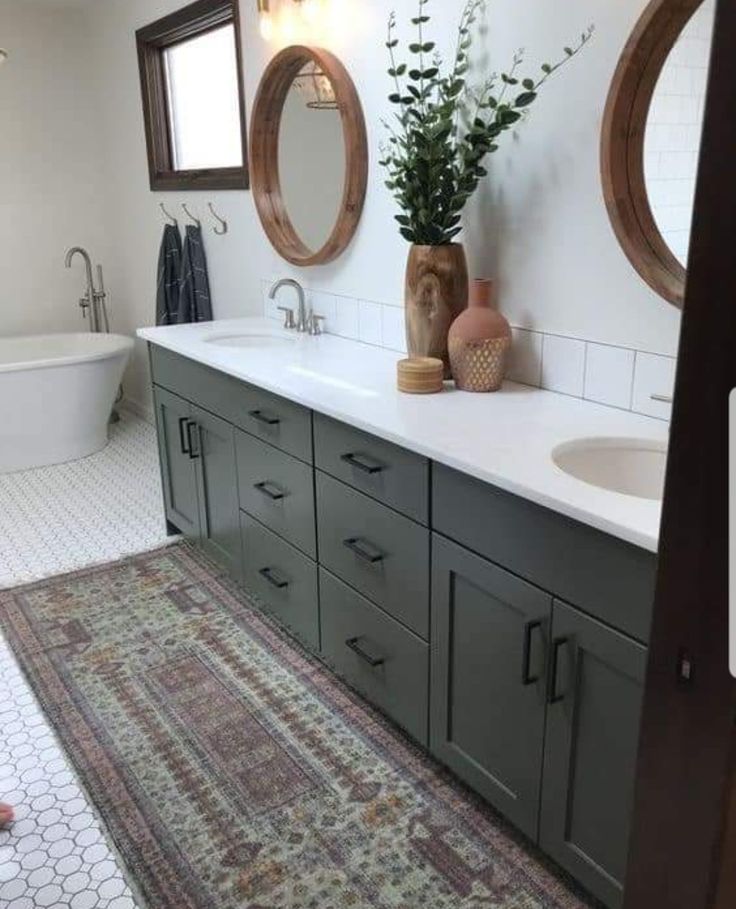 a bathroom with two sinks, a bathtub and a rug