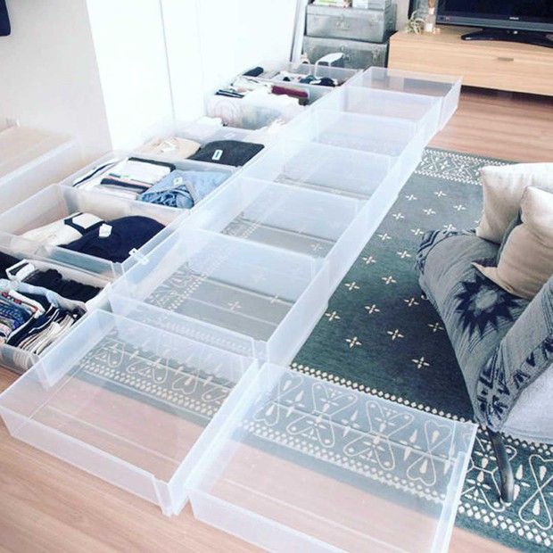 a living room filled with lots of drawers on top of a wooden floor next to a couch