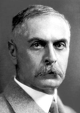 an old black and white photo of a man in a suit with a moustache