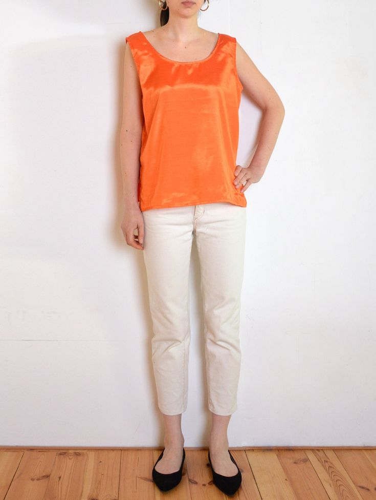 Beautiful vintage sleeveless blouse made of Thai silk fabric in nice tone of bright orange with some satin gloss. Classic sleeveless top fit. Round neckline, two side slits. Era: 90's, Thailand Fabric: 100% Thai silk Condition: very good Estimated size: L / XL / oversized (please, check the measurements) Measurements (measured flat, need to be doubled to get the circumference): Chest: 55 cm / 21,6 inches Length, from the top of the strap: 63 cm / 24,8 inches Sleeveless Silk Tops For Summer, Casual Sleeveless Silk Top, Spring Silk Sleeveless Tank Top, Silk Sleeveless Tank Top For Spring, Orange Silk Summer Tops, Orange Silk Top For Summer, Orange Silk Tops For Spring, Summer Orange Silk Tops, Sleeveless Silk Tank Top For Summer