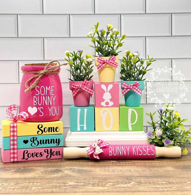 some wooden blocks are stacked on top of each other and decorated with pink, yellow, green and blue flowers