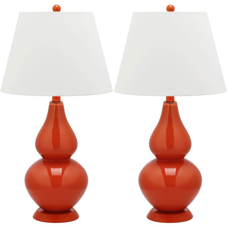 two orange lamps with white shades on them