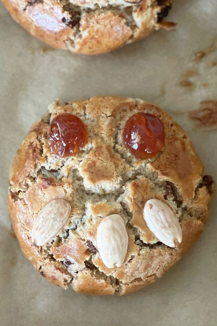 two cookies with almonds and cherries on them