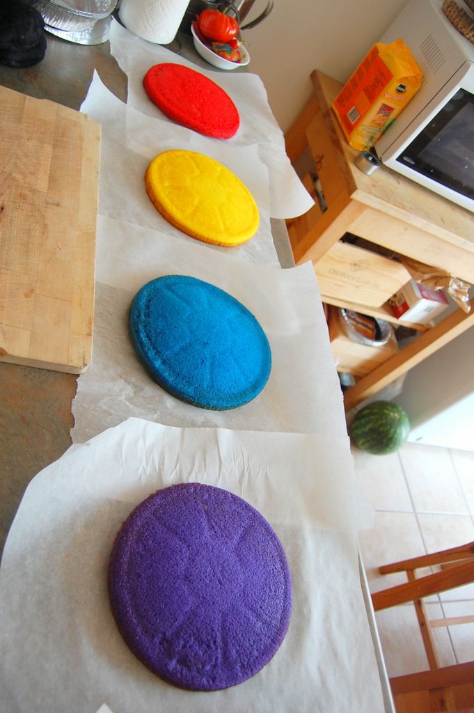 four different colored cookies sitting on top of white paper