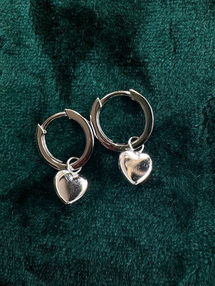 Crafted to Perfection - 925 Sterling Silver heart charm on hinged huggie Discover elegance and style with our exquisite 925 sterling silver hoop earrings. Each pair is a testament to craftsmanship, designed to elevate your fashion game and make a statement. Our collection offers 25 unique varieties, each with its own distinct charm and allure. - Made with high-quality 925 sterling silver for enduring beauty and durability. - Secure and easy-to-use closure for comfortable all-day wear. - Versatil Valentine's Day Small Hoop Huggie Earrings With Heart Charm, Anniversary Small Hoop Huggie Earrings With Heart Charm, Silver Heart Charm Huggie Earrings, Minimalist Sterling Silver Hoop Earrings For Valentine's Day, Silver Huggie Earrings With Heart Charm, Silver Huggie Earrings With Heart Charm For Anniversary, Trendy Small Hoop Sterling Silver Huggie Earrings, Silver Huggie Earrings For Valentine's Day Elegant Style, Trendy Sterling Silver Small Hoop Huggie Earrings