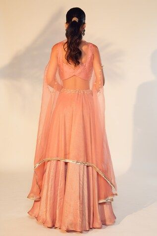 Dusty peach satin chinon lehenga with an attached cancan and pearls and cutdana hand embroidered waistband. Comes with a denting padded crop top and an organza cape. - Aza Fashions Peach Sharara With Sheer Dupatta, Fitted Peach Anarkali Set, Fitted Peach Sharara With Sheer Dupatta, Designer Wear Peach Lehenga, Peach Dress With Zari Work, Peach Lehenga With Traditional Drape, Fitted Peach Sharara With Resham Embroidery, Festive Fitted Peach Anarkali Set, Fitted Peach Dress For Reception