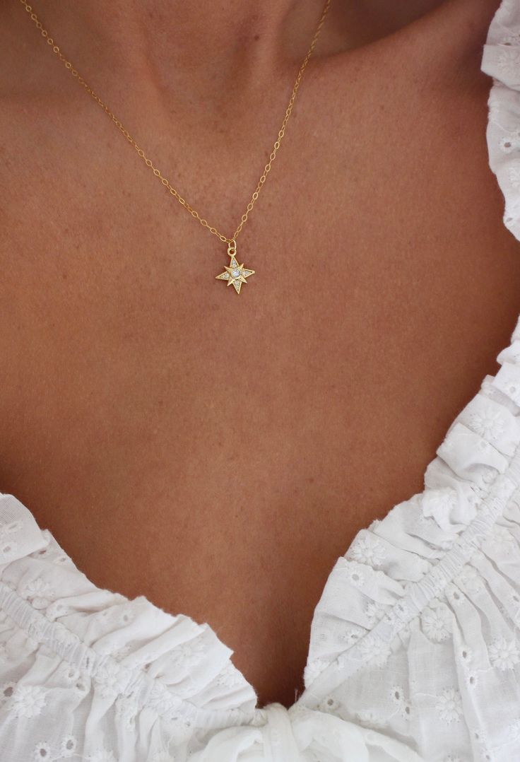 Gold Star Necklace | Small Star Necklace | Dainty Celestial Necklace | North Star Necklace | Constellation Jewelry | Layering Necklace DETAILS: * PENDANT is Gold Plated with Cubic Zirconia, measuring 12.5 mm x 14.5 mm * CHAIN is 14k Gold Filled * CLASP is 14k Gold Filled Model is wearing a 16 inch chain GOLD PLATED CARE: * Always remove jewelry before swimming, bathing, doing household chores, or using abrasive cleaners. * Apply beauty products such as perfume, hairspray or deodorant before wear Jewelry Layering Necklace, Gold Star Necklace, Constellation Jewelry, Jewelry Layering, North Star Necklace, Star Necklace Gold, Gold Necklace Simple, Gold Pendant Jewelry, Celestial Necklace