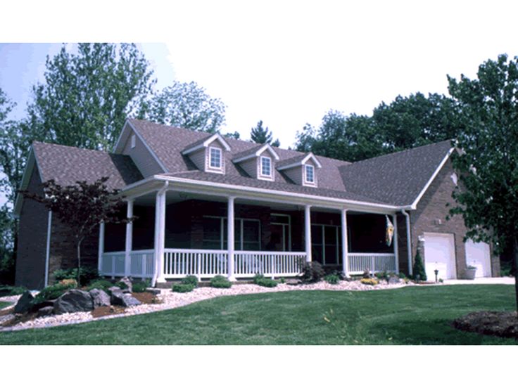 a large house with wraparound porches and covered front porchs on the grass