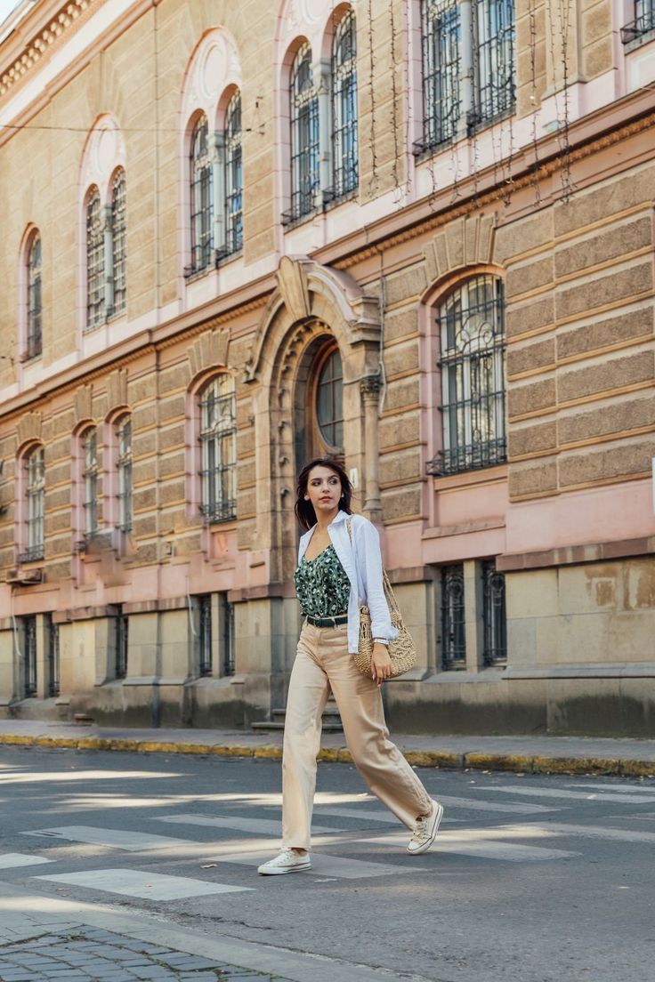 a woman crossing the street in front of an old building