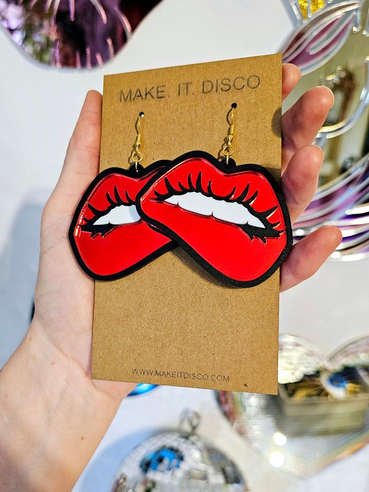 Turn up the heat and add a touch of flirtatious fun to your ear holes with our 'Bite Me' earrings. A seductive pair of pop art ear danglers that are sure to make a statement!  Perfect for festival season, that big night out, or just lounging around the house! You do you.  Measurements: Each earring measures 6cm width x 5cm height, with an additional drop of 2cm with the hook finding.  Materials: 1mm thick black gloss acrylic backing, layered with 3mm acrylic, giving each earring an overall depth Trendy Jewelry For Valentine's Day Party, Single Earring For Valentine's Day Party, Unique Adjustable Earrings For Party, Unique Dangle Plug Earrings For Party, Handmade Adjustable Plug Earrings For Party, Adjustable Pierced Earrings For Parties, Adjustable Fun Party Earrings, Handmade Party Plug Earrings, Quirky Red Jewelry For Gifts