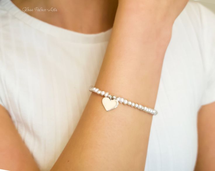 Fall in love all over again with this glimmering silver heart and pearl bracelet....................... White/ Ivory freshwater pearls are AA quality and measure about 2mm Shiny sterling heart measures about 13mm Chain is dainty 925 sterling silver Bracelet is adjustable (choose your size) Bracelet closes with a sterling silver spring clasp This is a handmade item and made for you after the order is placed PACKAGINGAll Jewelry is carefully packaged for a safe arrival and is secured in a jewelry Silver Beaded Charm Bracelet With Heart Shape, White Heart Bracelet With Pearl Charm, Silver Heart-shaped Beaded Charm Bracelet, Silver Beaded Heart-shaped Charm Bracelet, Silver Heart-shaped Pearl Bracelet For Gift, Silver Beaded Heart Charm Bracelet, Heart-shaped Beaded Pearl Bracelet Gift, Pearl Beaded Bracelets With Heart Beads, White Heart-shaped Bracelet With Pearl Charm