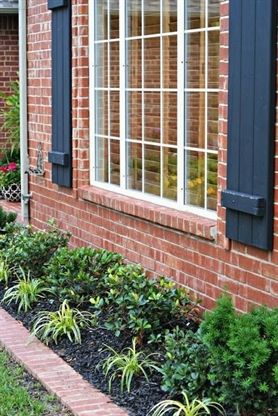 a brick house with blue shutters on the windows