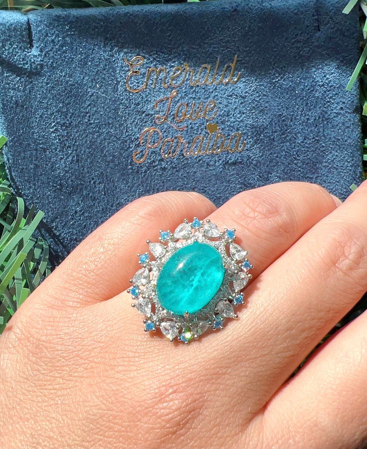 4 Cabochon PARAIBA Blue Halo Vintage Style Ring, Magnificent Vivid Ocean Blue Statement Ring For Her Adjustable Size 6-8 w 18KGP Mainstone size is 8x10mm 4 Carat Overall size is 22x22mm ♥Ready to ship ♥ The main stone is the Finest Doublet PARAIBA TOURMALINE. ♥Absolutely gorgeous and beautifully handcrafted Finest Doublet PARAIBA TOURMALINE in an exquisite setting. ♥ This classic yet trendy Jewelry makes the perfect Christmas/Anniversary/Valentine's/Birthday gift for her that will be treasured f Fine Jewelry Blue Cabochon Sapphire Ring, Blue Cabochon Sapphire Ring In Fine Jewelry Style, Blue Cabochon Diamond Ring, Formal Cabochon Blue Topaz Jewelry, Blue Diamond Cabochon Ring, Blue Emerald Rings With Halo Setting, Blue Emerald Ring With Halo Setting, Blue Diamond Ring With Cabochon Cut, Blue Emerald Halo Setting Ring