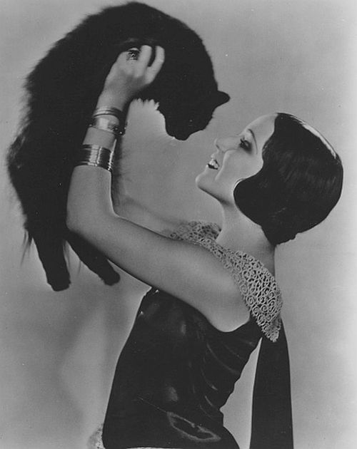 black and white photograph of a woman holding a cat