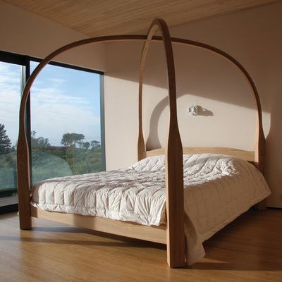 a bed sitting on top of a hard wood floor next to a large glass window