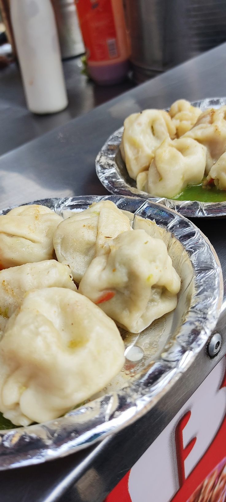 two plates filled with dumplings sitting on top of a table next to each other