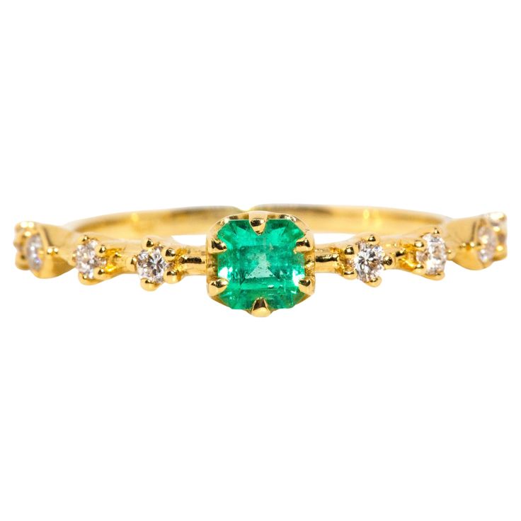 Crafted in 18 carat yellow gold, this delightful contemporary ring holds an alluring natural green emerald flanked by eight glistening round brilliant cut diamonds shimmering in unison. Her name is The Ruri Ring, the perfect ring for stacking with other beloved gems and jewels or wearing alone. The Ruri Ring Gemstone Details The bright green square emerald cut emerald is 0.31 carats and measures approximately 4.00x3.87x3.2 millimetres. The round brilliant cut diamonds total 0.20 carats and F colour and VS clarity grades. Ring Size M (Australia and UK sizing) or 6 1/4 (US and Canada) The Ruri Ring can be resized prior to shipping upon request. Resizing is complimentary up or down three sizes or please message us for a quote if more sizes are needed. Great to Know The Ruri Ring belongs to ou