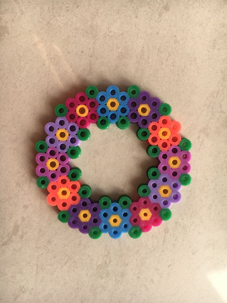 a colorful beaded bracelet on a white surface with space for the letter o in the middle