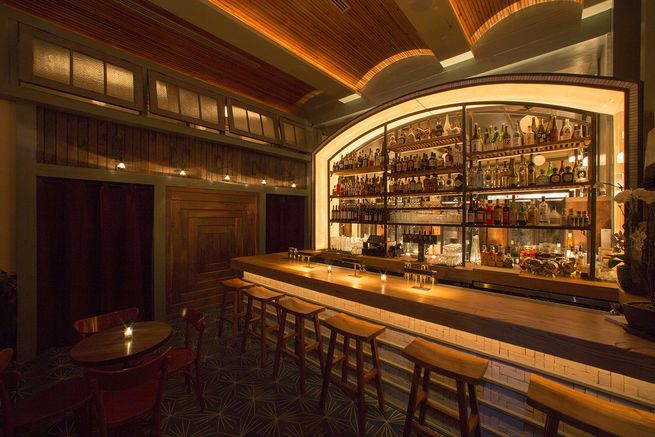 a dimly lit bar with wooden stools