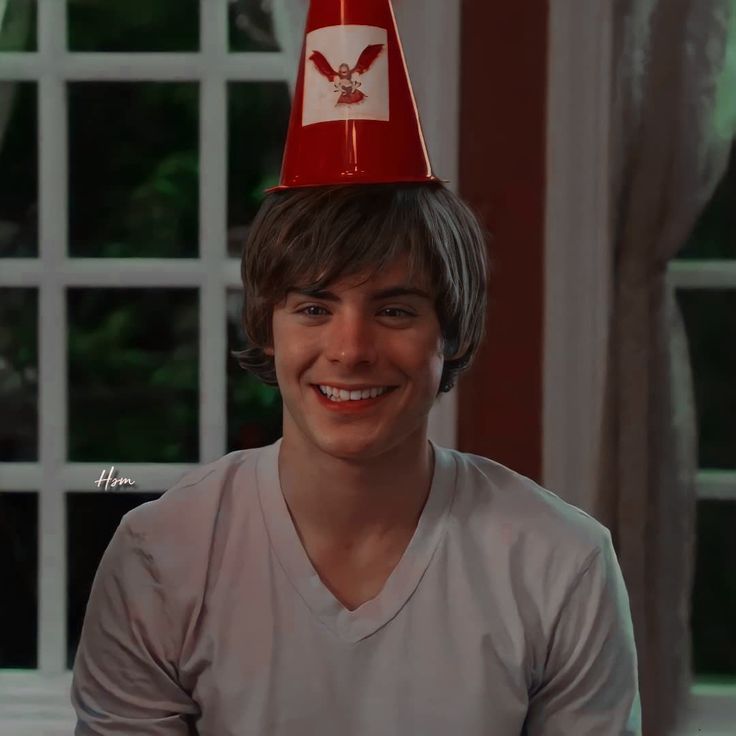 a young man wearing a red hat with an eagle on it