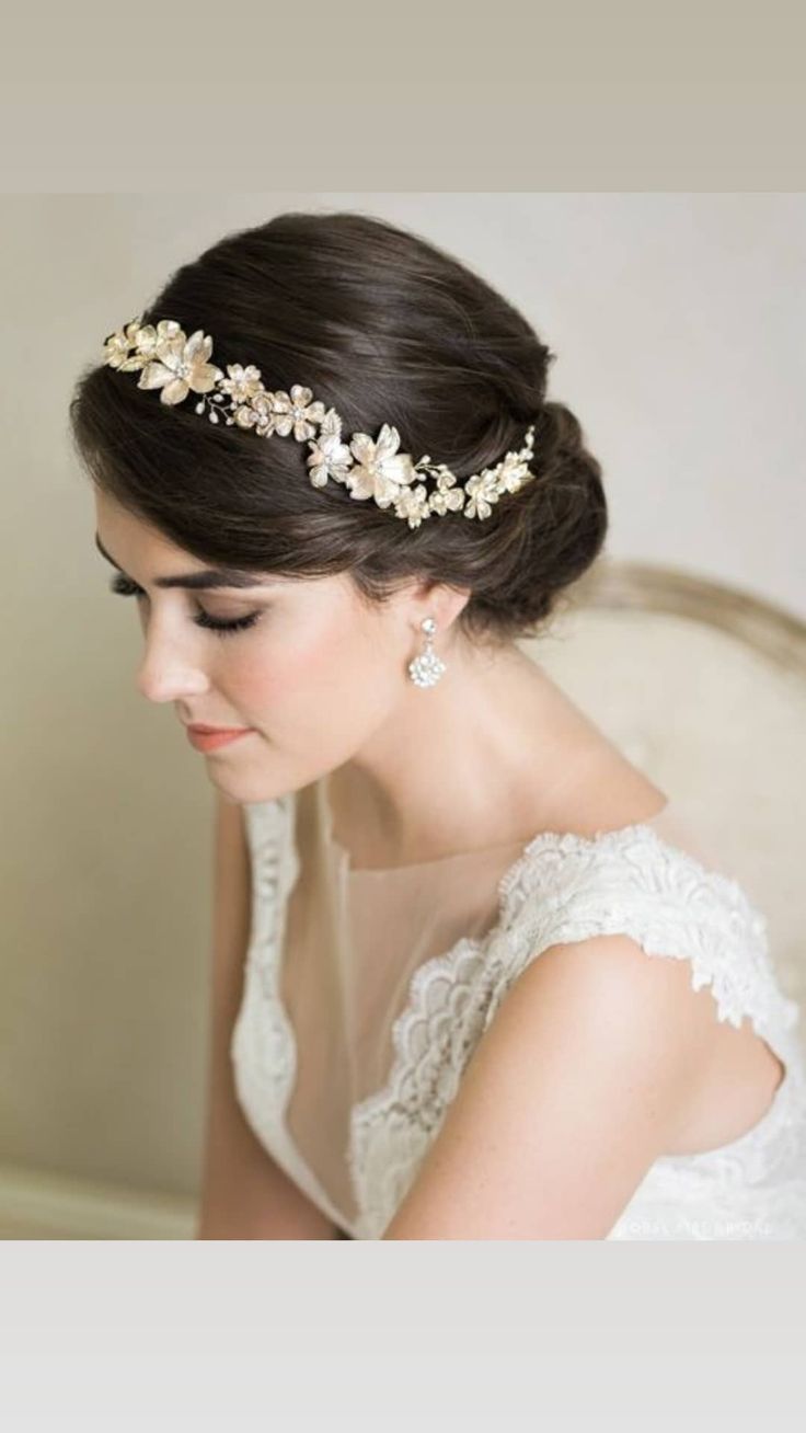 a woman wearing a bridal headpiece with flowers on it's side and pearls in her hair