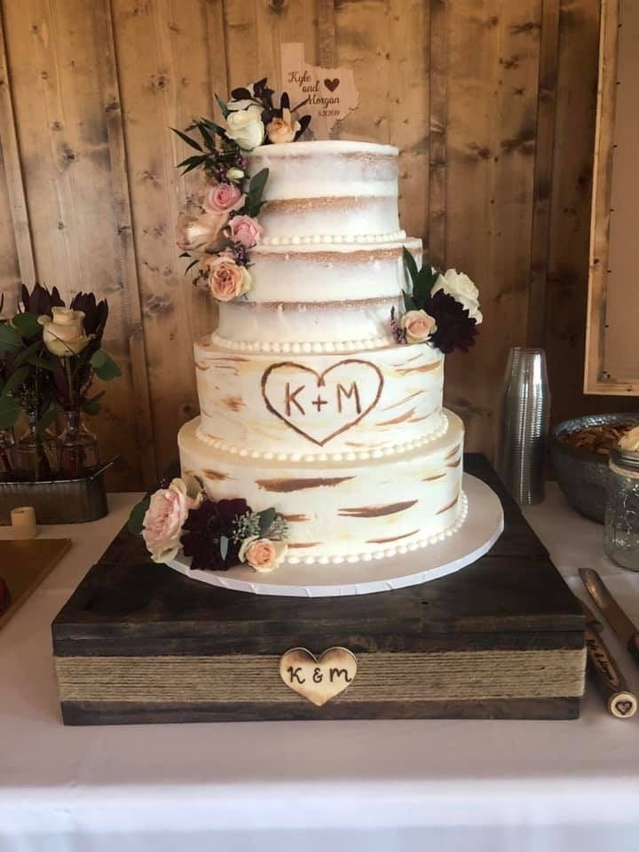 a wedding cake with flowers and initials on it