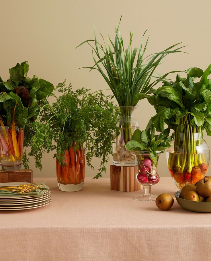 a table topped with vases filled with different types of vegetables