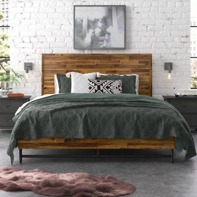 a bedroom with white brick walls and green bedding, along with an animal rug