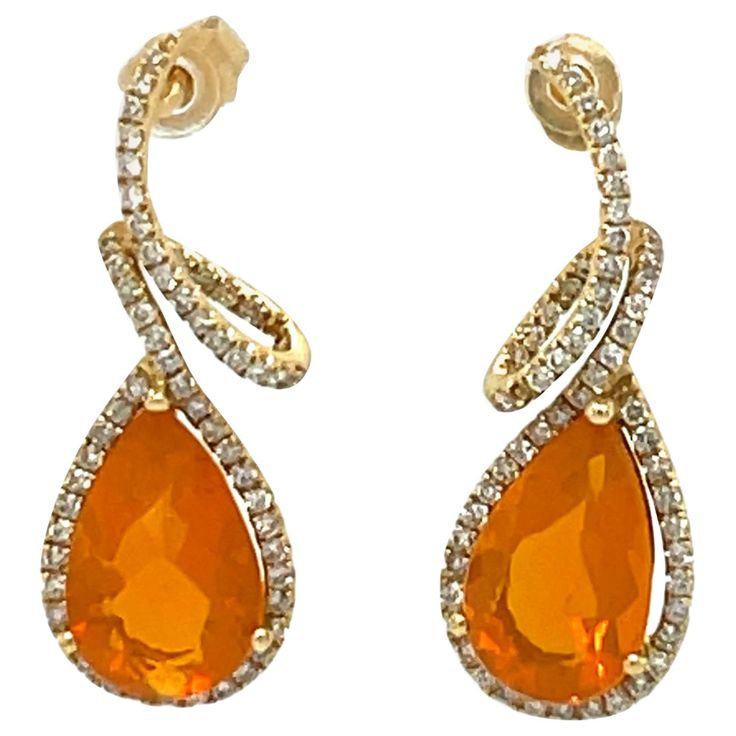 These vibrant 14x8 mm Teardrop Fire Opal and diamond dangling earrings are set in 14 karat yellow gold. They are stunning to wear at that special event. They have a halo of sparkling diamonds and a swirl design for a beautiful accent. These earrings are approximately 1.25" in length and have push back closure. These earrings will be shipped in a beautiful box, ready for the perfect gift! They are brand new with original tags attached. Gold: 3.50 gms 14K yellow Gold Stone: 4.28 ct pear shap Fire Opal, 14x8 mm Diamond: 0.72 cts, 116 round brilliant cut diamonds, Color: H, Clarity: S/I FREE SHIPPING, within the US. Usually ships within 1-2 business days Retail value: $3,750 Diamond Dangling Earrings, Mens Diamond Jewelry, Fire Opal Earrings, Gold Stone, Swirl Design, Dangling Earrings, Opal Earrings, Sparkle Diamonds, Round Brilliant Cut Diamond