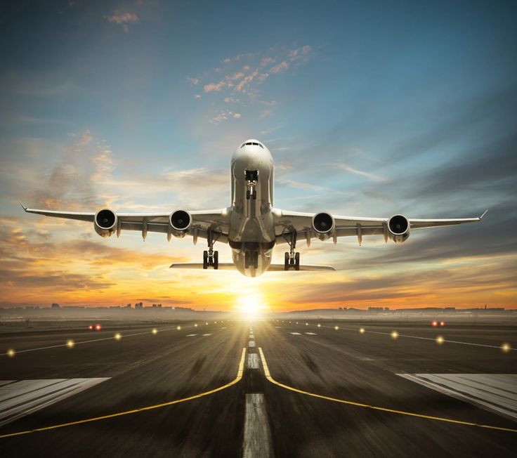 an airplane is taking off from the runway at sunset or dawn with its landing gear down