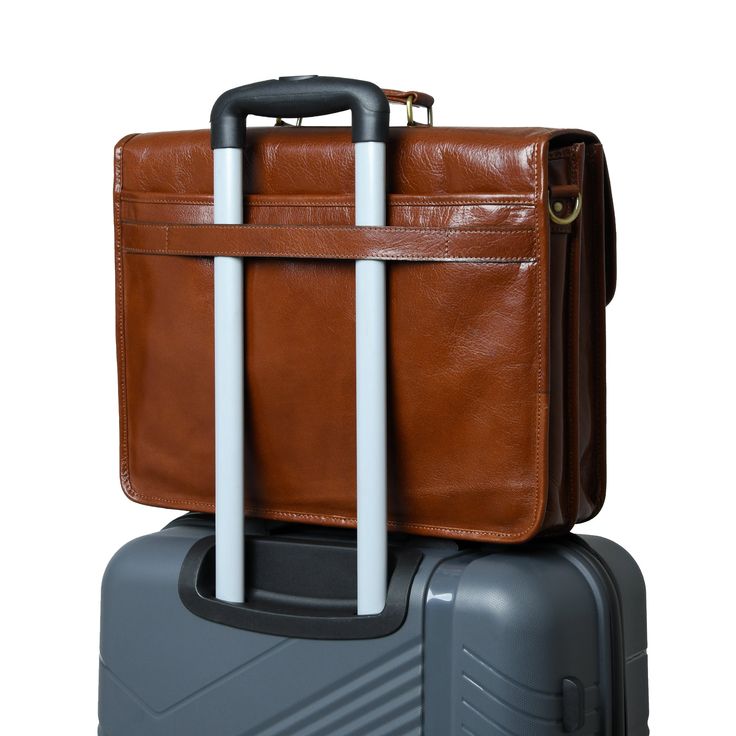 two pieces of luggage stacked on top of each other, one brown and the other grey