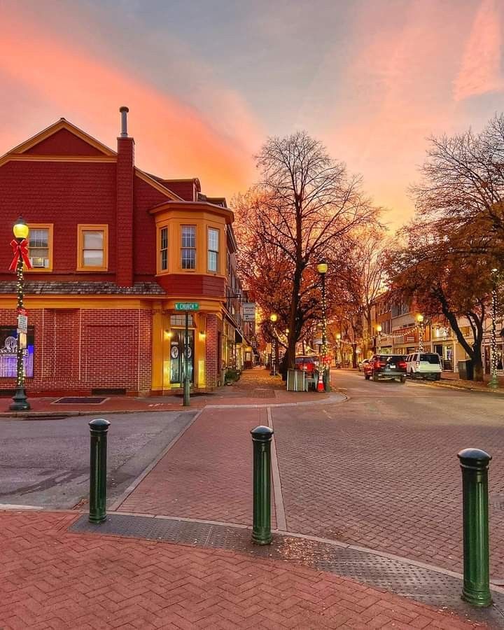 a red brick building sitting on the side of a road next to a street light