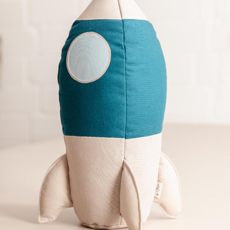 a stuffed toy rocket ship sitting on top of a table