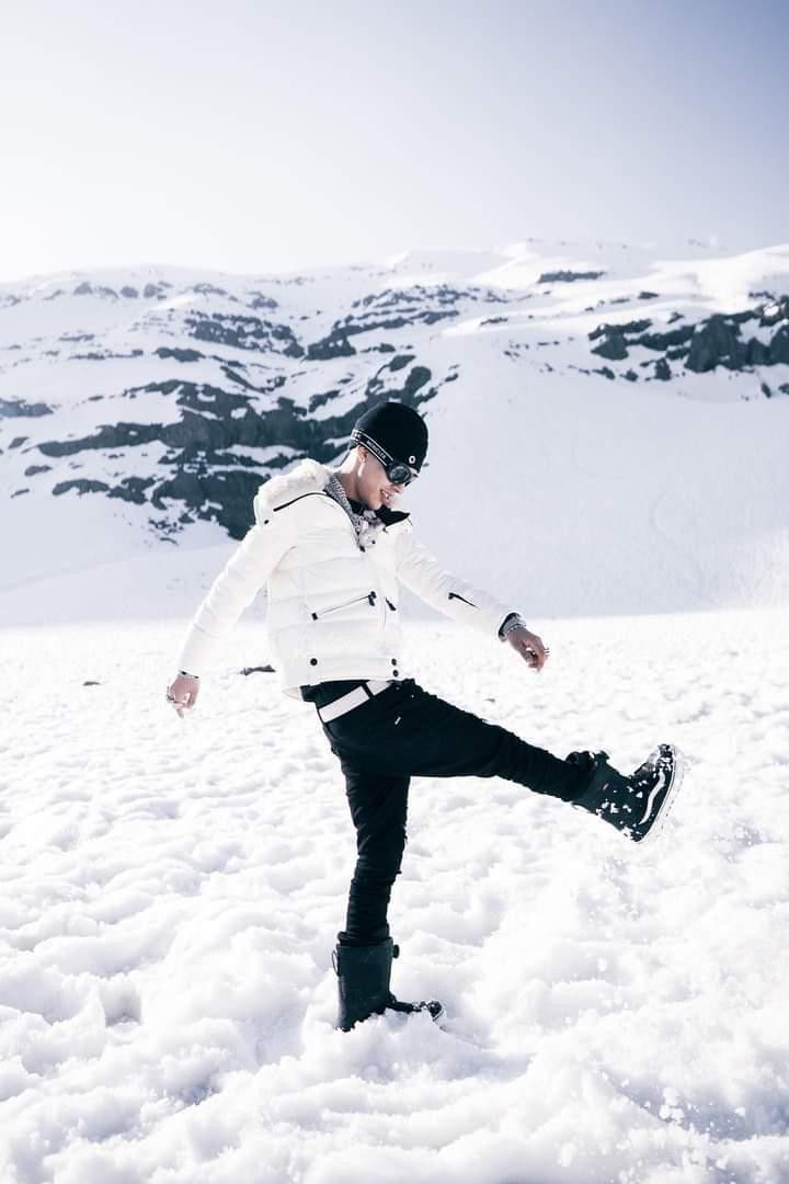 a man standing in the snow with his legs spread out