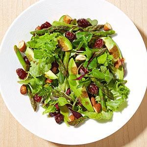 a white plate topped with salad on top of a wooden table