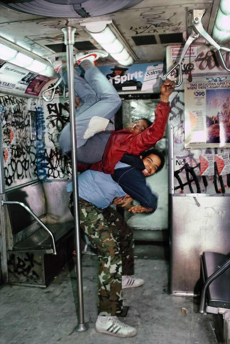 two people hanging upside down on a bus