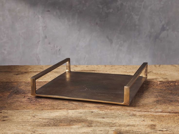 a square metal tray sitting on top of a wooden table