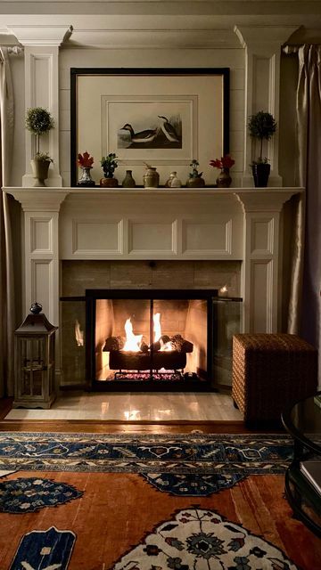 a living room with a fire place and rugs on the floor in front of it