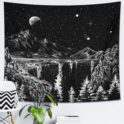 a black and white tapestry hanging on a wall next to a potted plant in front of a window