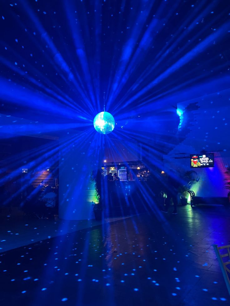 a large room with blue lights and stars on the floor in front of a tv