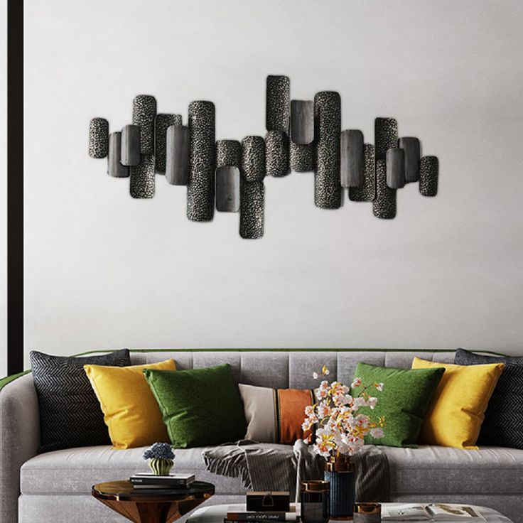 a living room filled with lots of furniture next to a wall mounted art piece on the wall