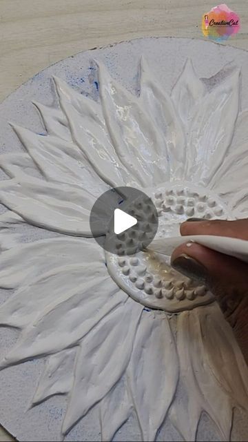 someone is painting a flower with white paint