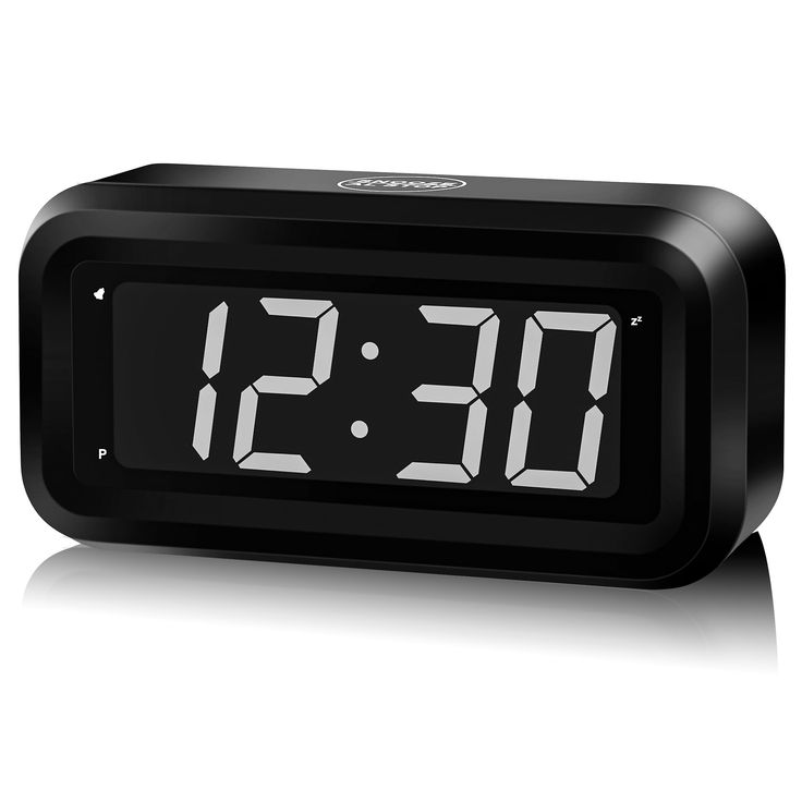 the alarm clock is black and has white numbers on its face, as if it were from an old time radio